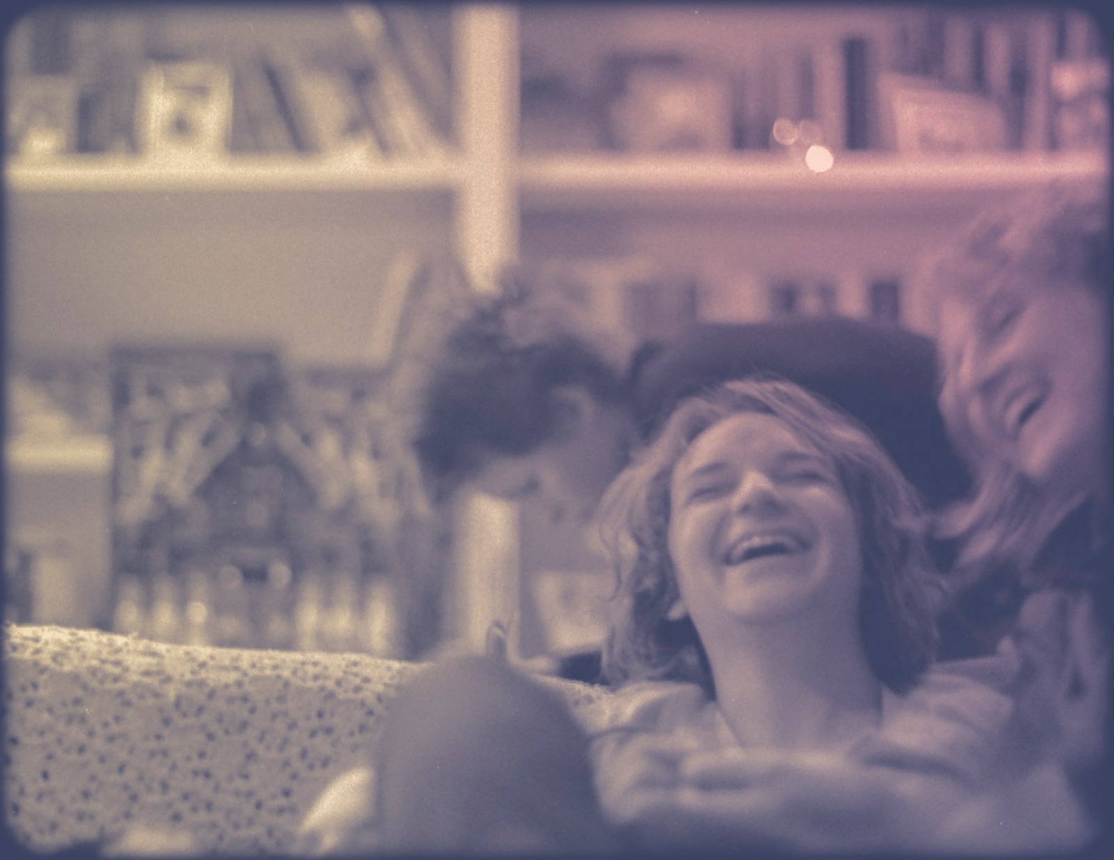 Friends curled up on a couch, laughing together